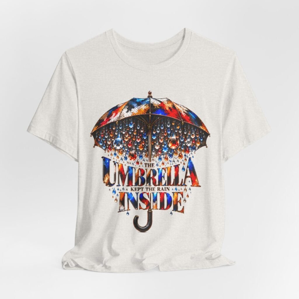 Colorful umbrella graphic T-shirt featuring “The Umbrella Kept the Rain Inside” artistic typography and jewel-like raindrops.